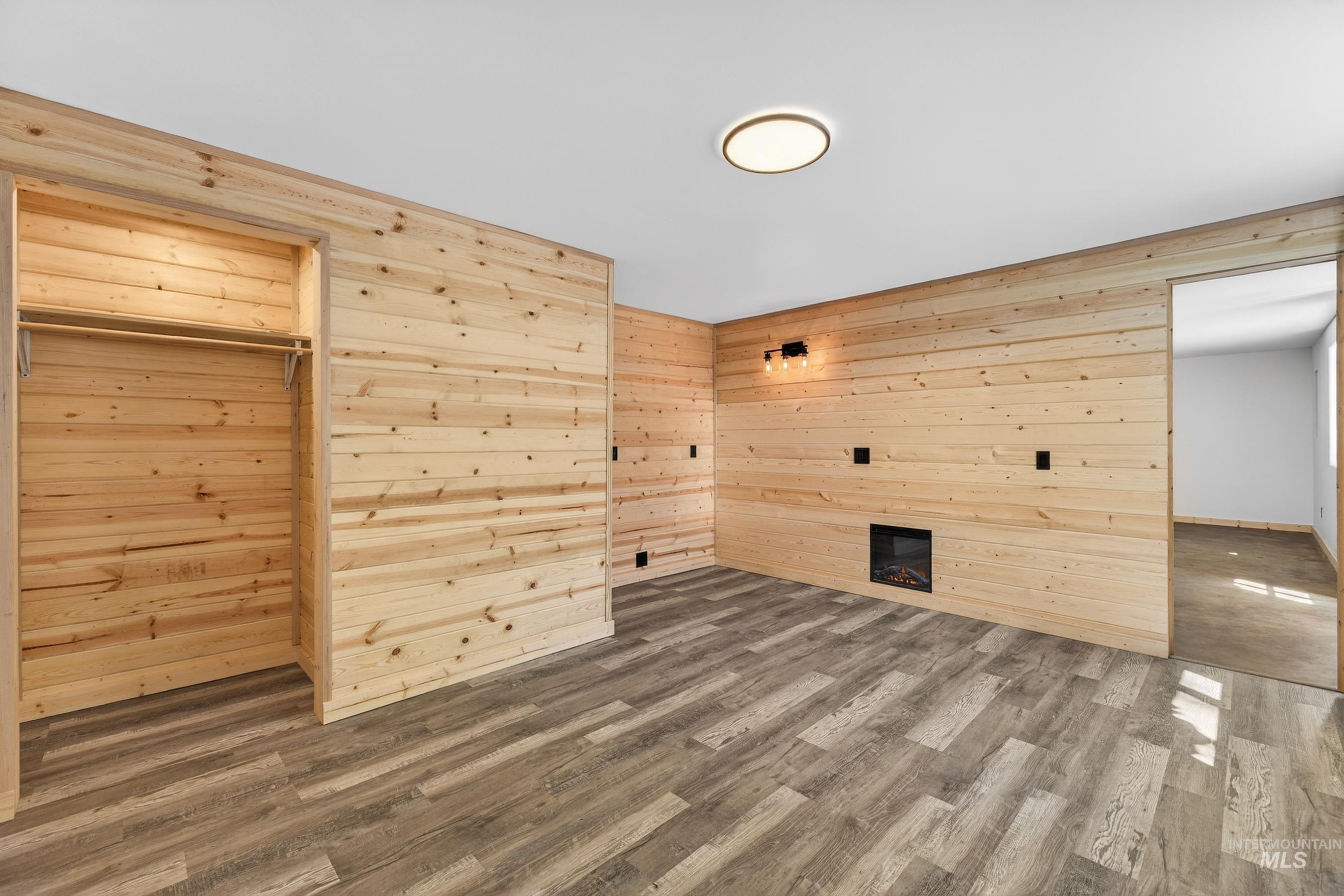 543 North Main Street Riggins, ID 83549 - Photo 36 of 46 Unfurnished living room with wooden walls, dark wood finished floors, and a glass covered fireplace