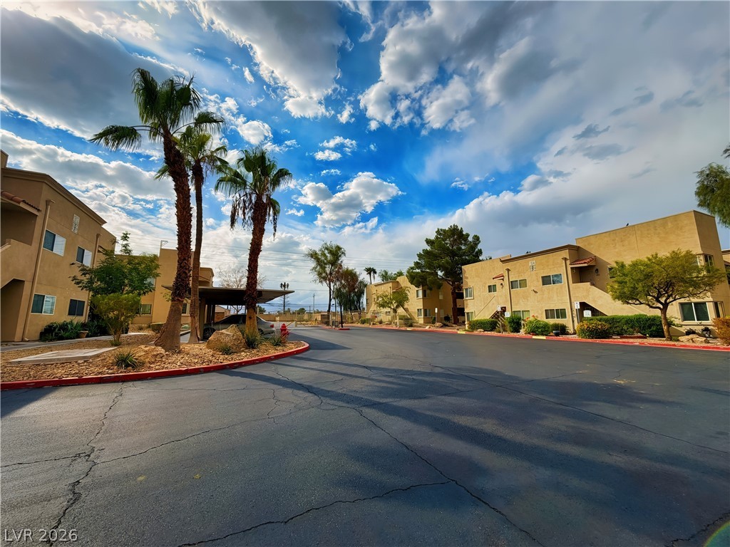 1852 North Decatur Boulevard, Unit 101 Las Vegas, NV 89108 - Photo 23 of 45 Mature palms and paved streets frame the stucco exteriors of this residential community.