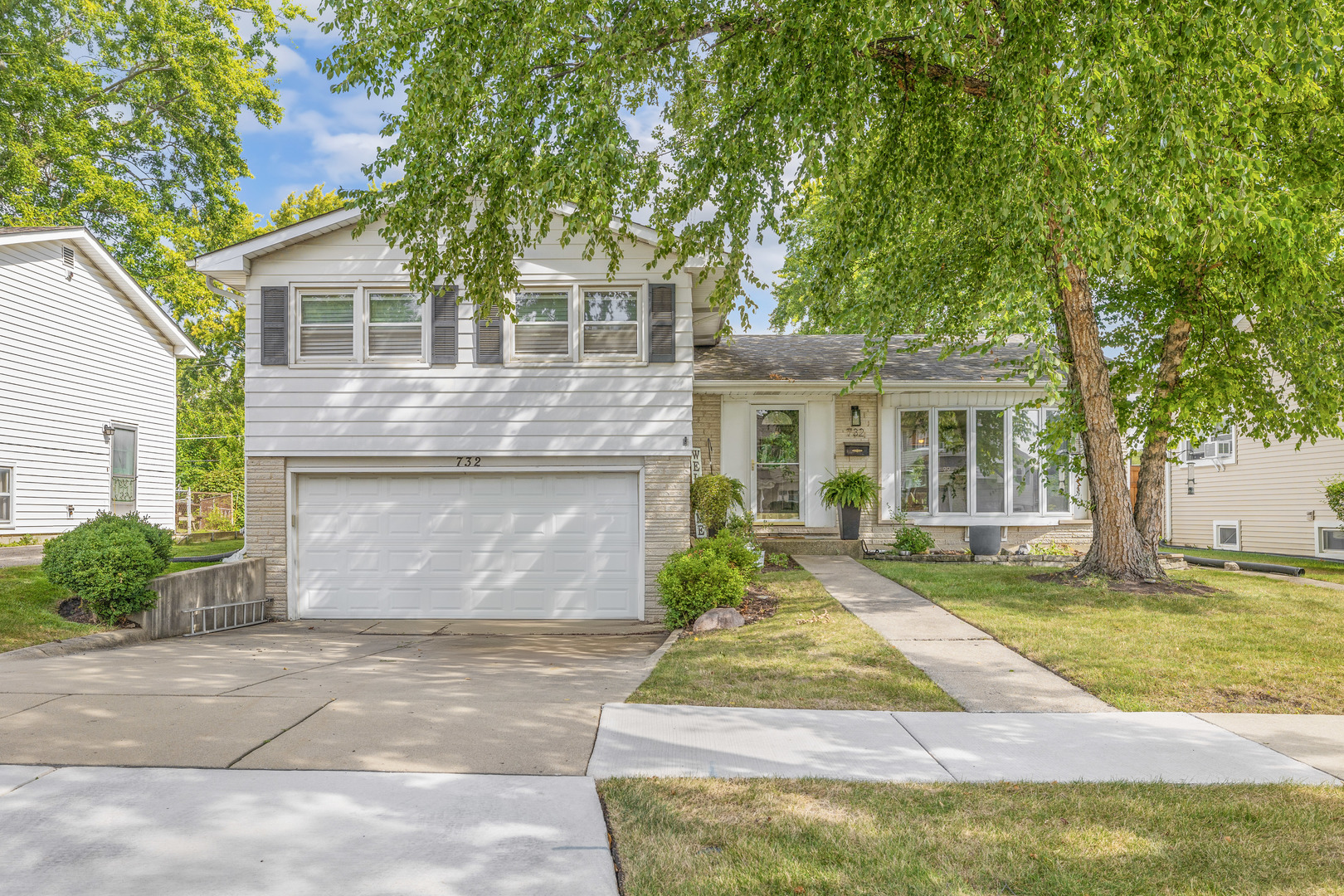 a front view of a house with a garden and yard