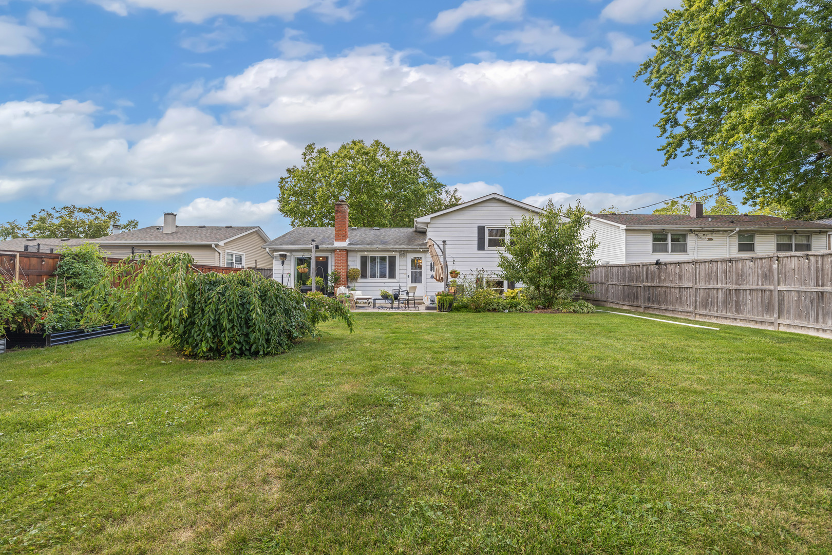 732 Sandy Lane Des Plaines, IL 60016 - Photo 16 of 17 a view of a house with a big yard and potted plants