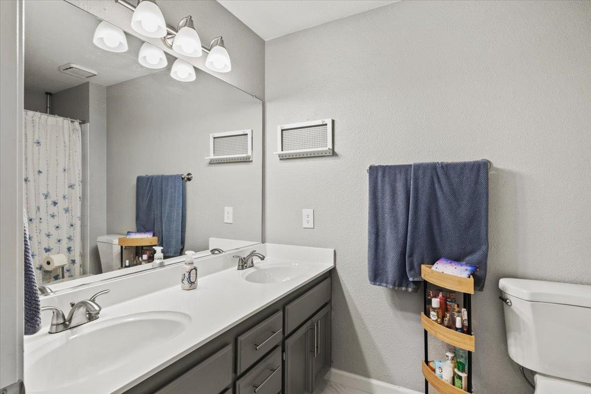 5303 Elgin Hills Way Antelope, CA 95843 - Photo 23 of 33 a bathroom with a sink a toilet and a mirror