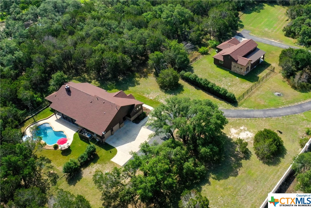 an aerial view of a house with swimming pool and outdoor seating
