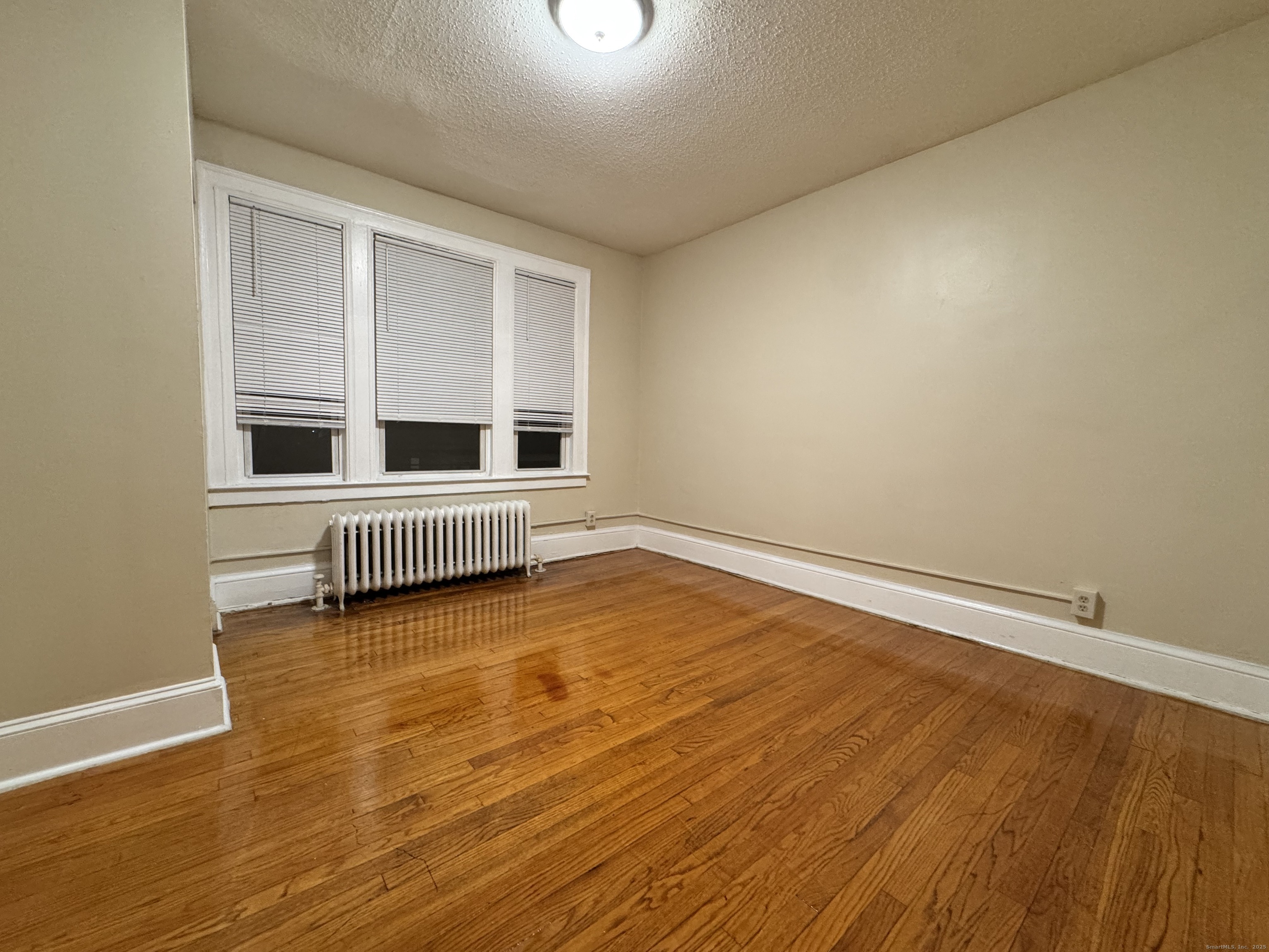 75 Whitmore Street Hartford, CT 06114 - Photo 4 of 6 a view of an empty room with wooden floor and a window