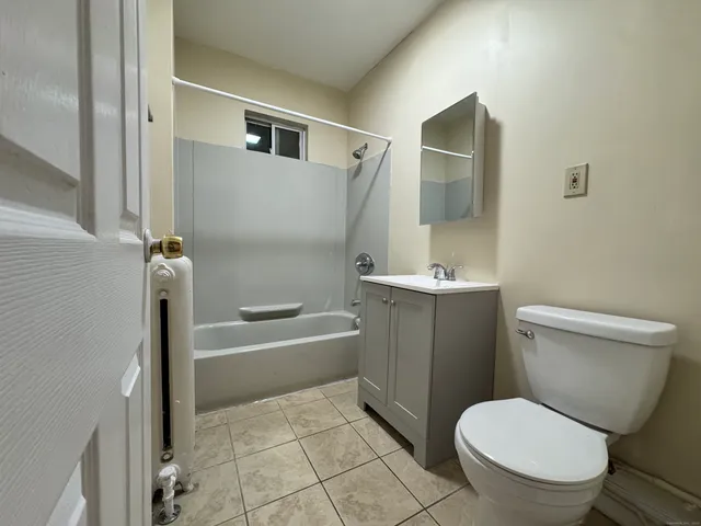 a white toilet sitting next to a bathroom sink and tub