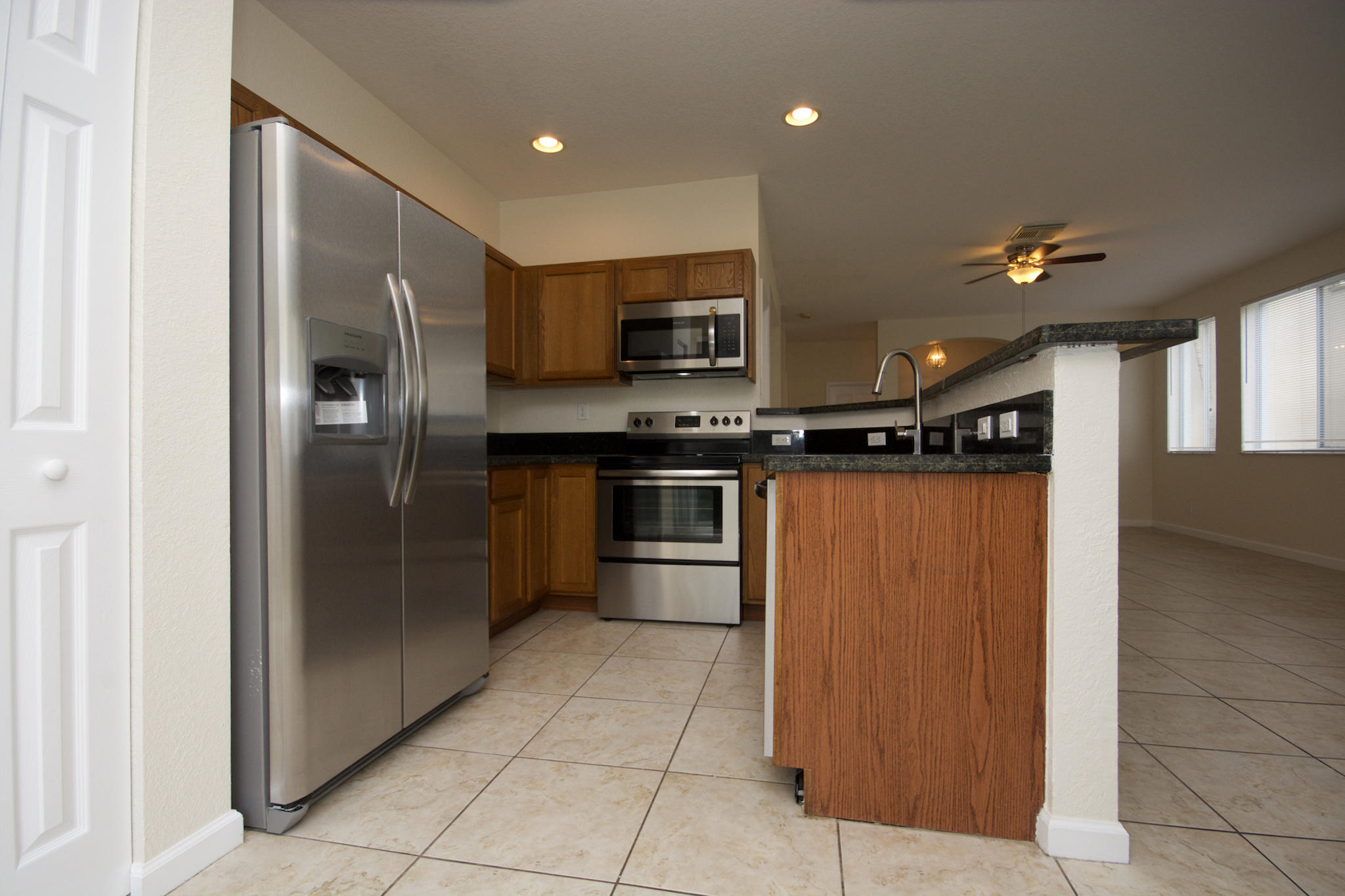 3227 Laurel Ridge Circle Riviera Beach, FL 33404 - Photo 5 of 27 a kitchen with stainless steel appliances granite countertop a refrigerator and a sink
