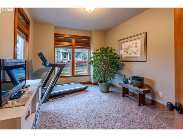 a living room with furniture gym equipment and a large window