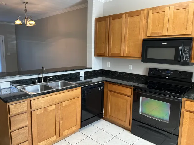 a kitchen with stainless steel appliances granite countertop a sink stove and microwave