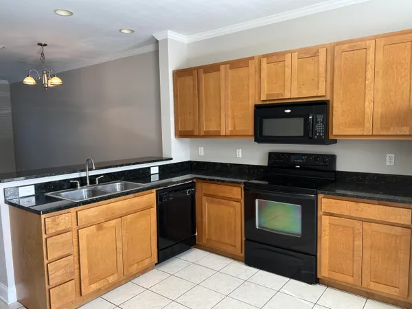 a kitchen with granite countertop cabinets stainless steel appliances and a sink