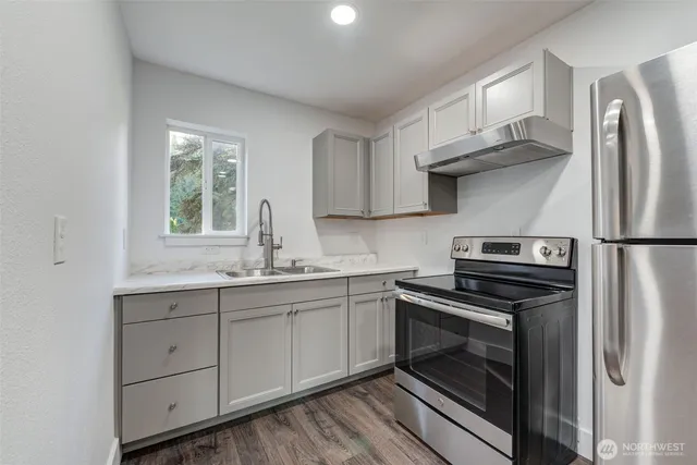 a kitchen with stainless steel appliances granite countertop a refrigerator sink and stove