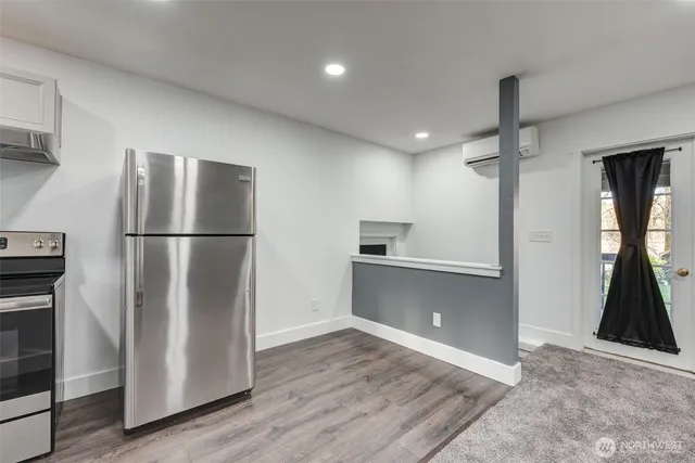 a kitchen with kitchen island a refrigerator and a stove top oven