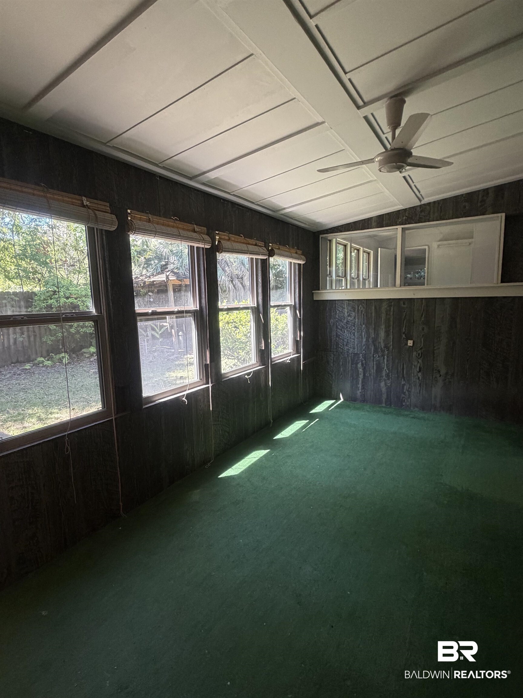 1354 Caney Loop Lillian, AL 36549 - Photo 23 of 45 Sunroom featuring multiple windows, sloped ceiling, overhead fan, paneled walls, and green carpeting