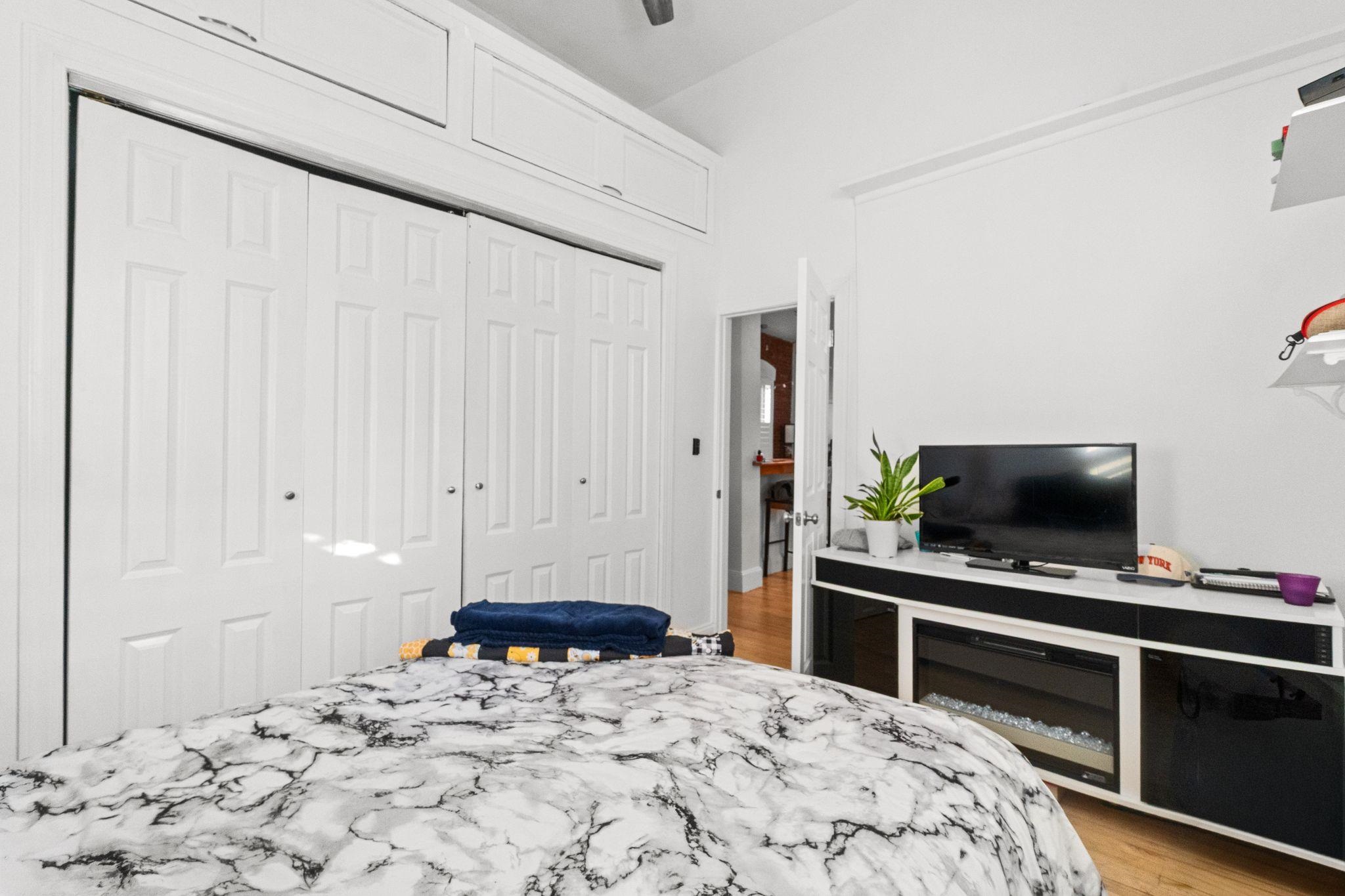 76 Jackson Street, Unit 4R Hoboken, NJ 07030 - Photo 12 of 17 a bedroom with a bed and a flat screen tv