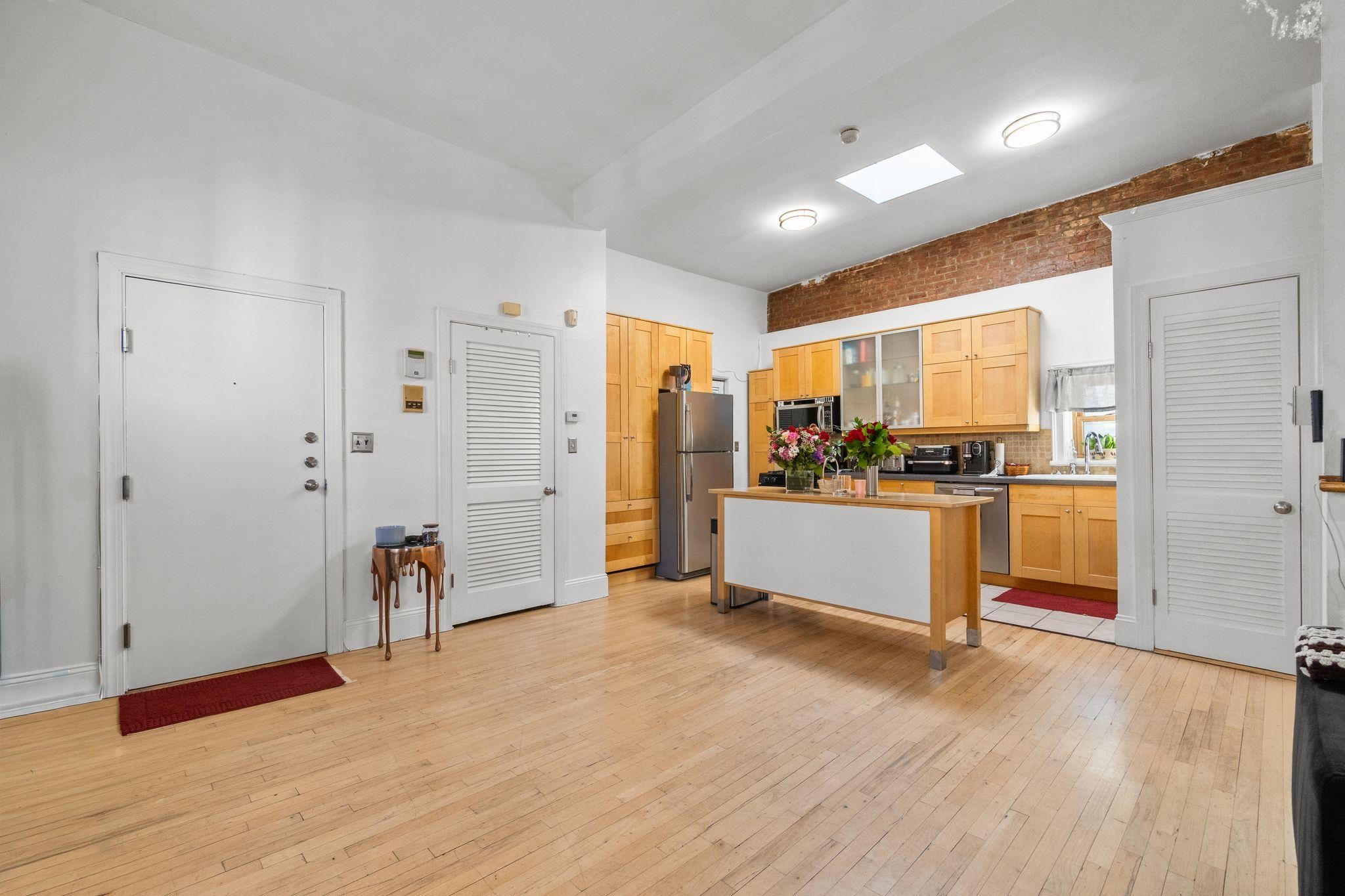 76 Jackson Street, Unit 4R Hoboken, NJ 07030 - Photo 4 of 17 a view of a kitchen with refrigerator and white cabinets