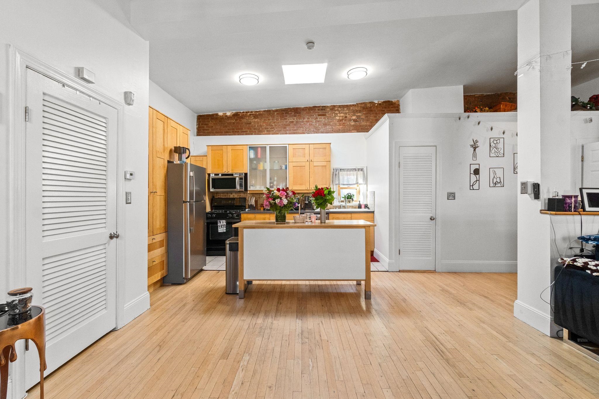 76 Jackson Street, Unit 4R Hoboken, NJ 07030 - Photo 5 of 17 a view of a kitchen with kitchen island wooden floors appliances and cabinets