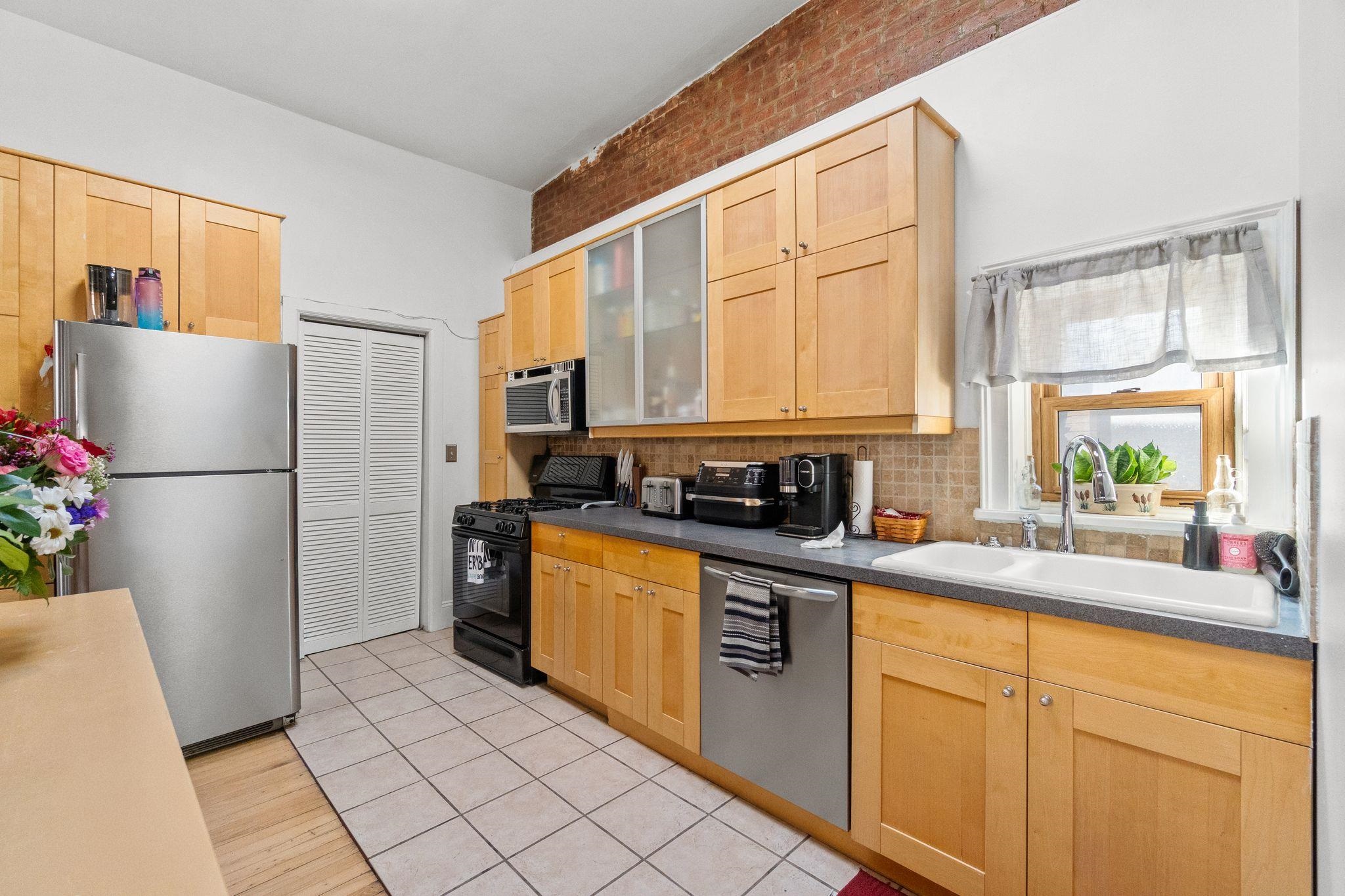 76 Jackson Street, Unit 4R Hoboken, NJ 07030 - Photo 6 of 17 a kitchen with stainless steel appliances granite countertop a refrigerator a sink a stove a microwave and cabinets