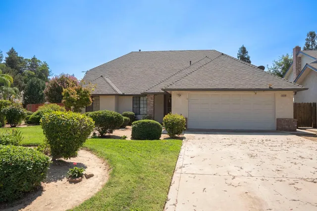 a front view of a house with a yard and potted plants