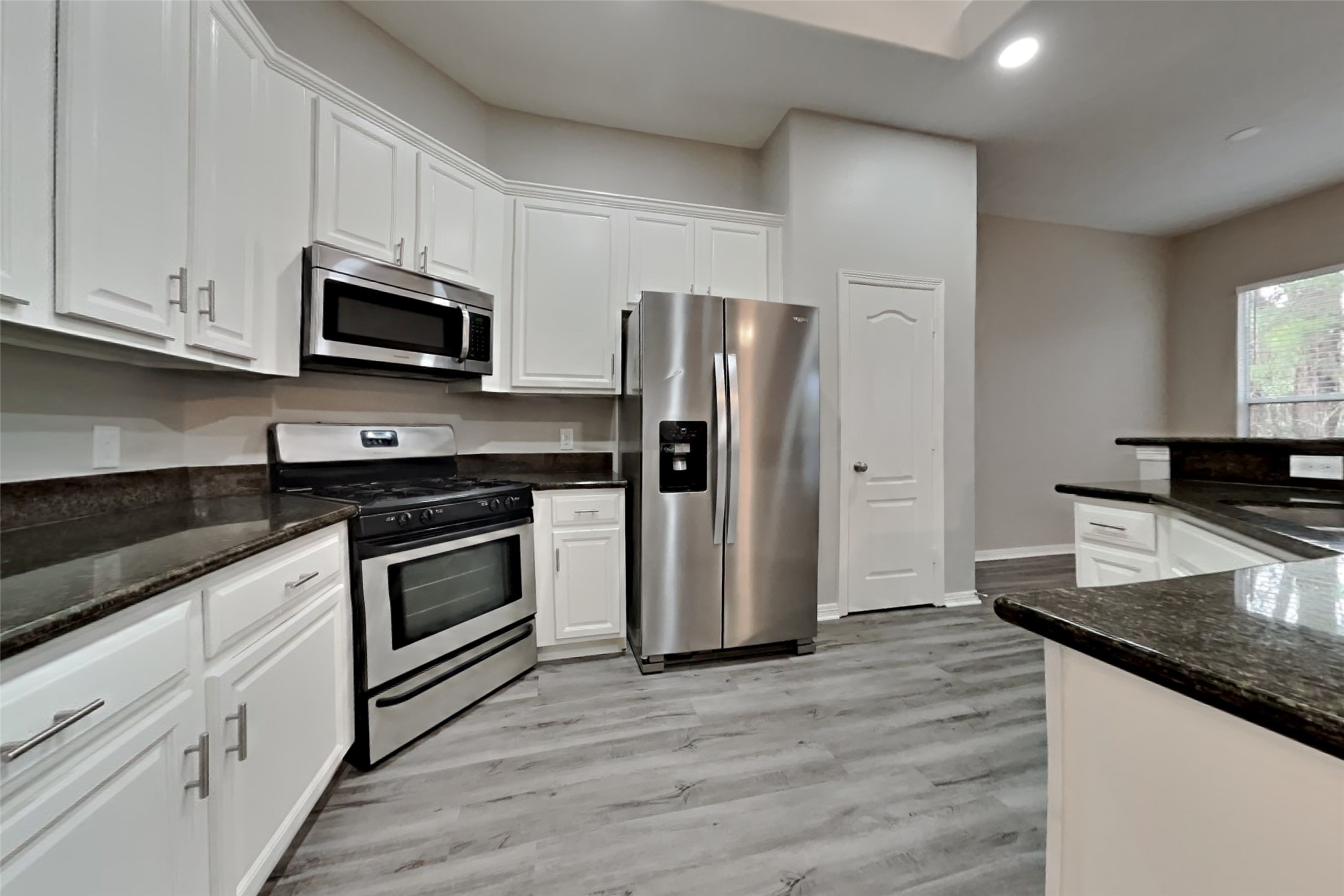 18730 Dempsey Oaks Drive Humble, TX 77346 - Photo 4 of 18 a kitchen with stainless steel appliances granite countertop a stove a refrigerator and a microwave