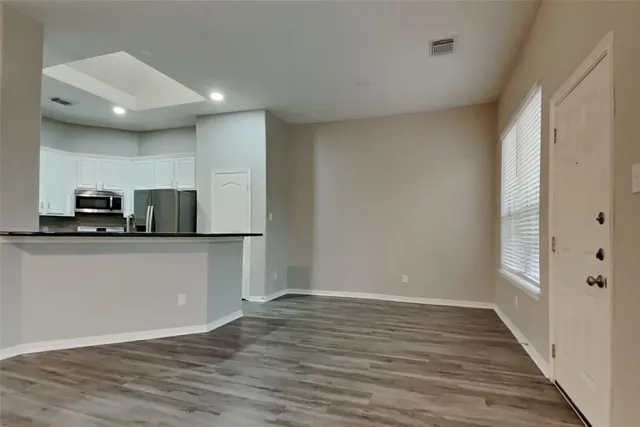 a view of kitchen with wooden floor and electronic appliances