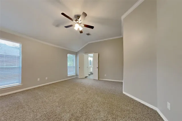 a view of an empty room with a chandelier fan