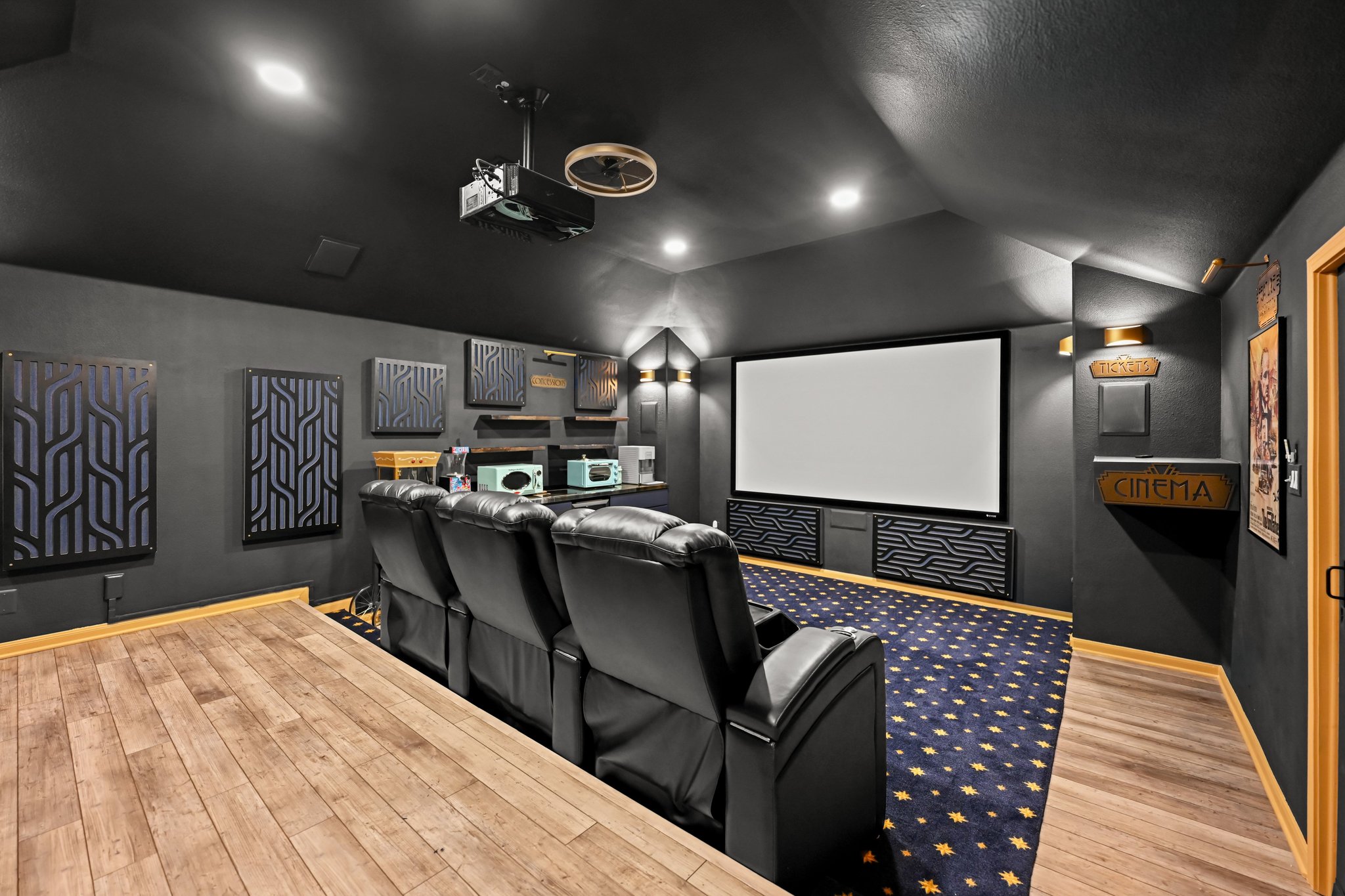 5528 Wild Foxglove Road Spicewood, TX 78669 - Photo 24 of 38 Dedicated media room featuring a large projection screen, tiered seating, wall-mounted acoustic panels, wood-finish flooring, and recessed ceiling lighting