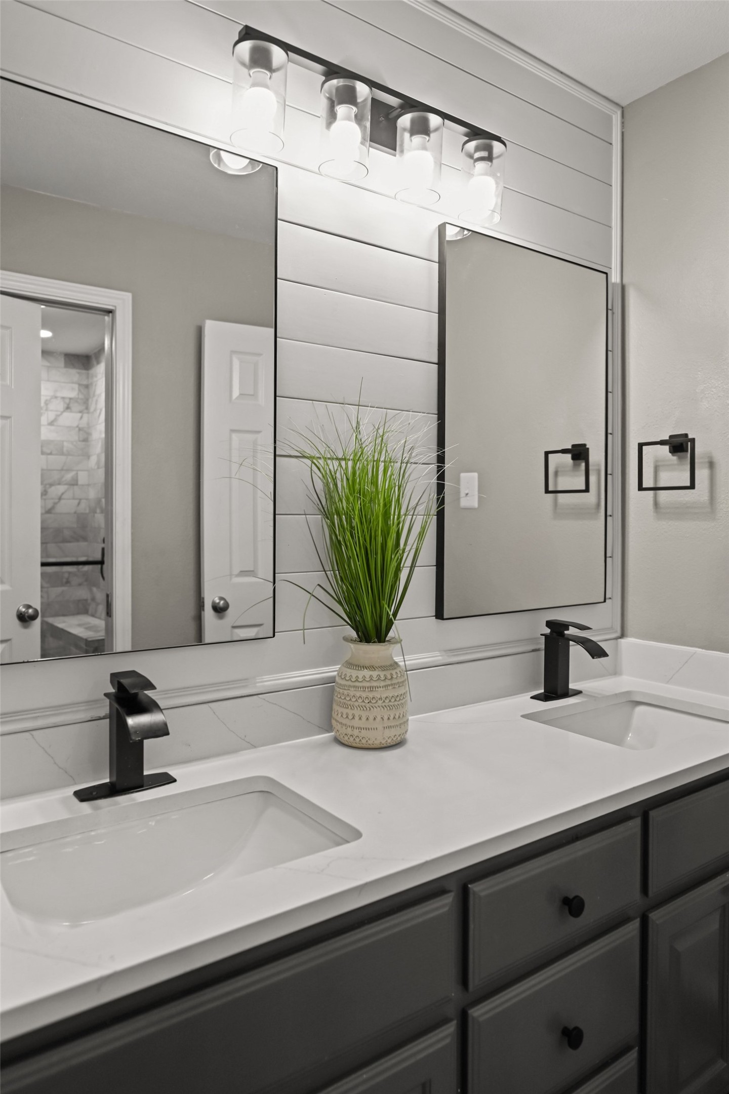 5528 Wild Foxglove Road Spicewood, TX 78669 - Photo 26 of 38 Double vanity with undermount sinks, white countertop, and dark gray cabinetry