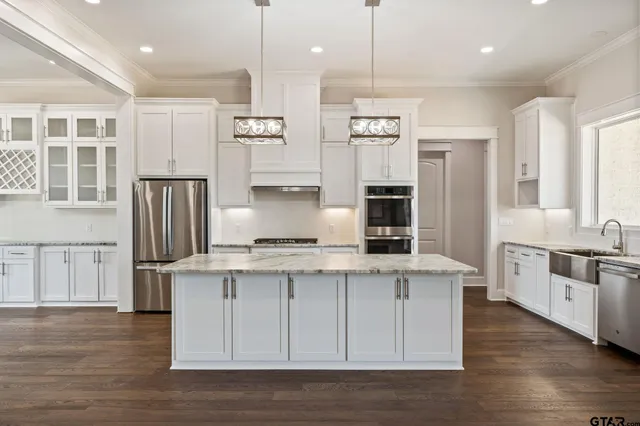 a kitchen with stainless steel appliances granite countertop a stove and a refrigerator