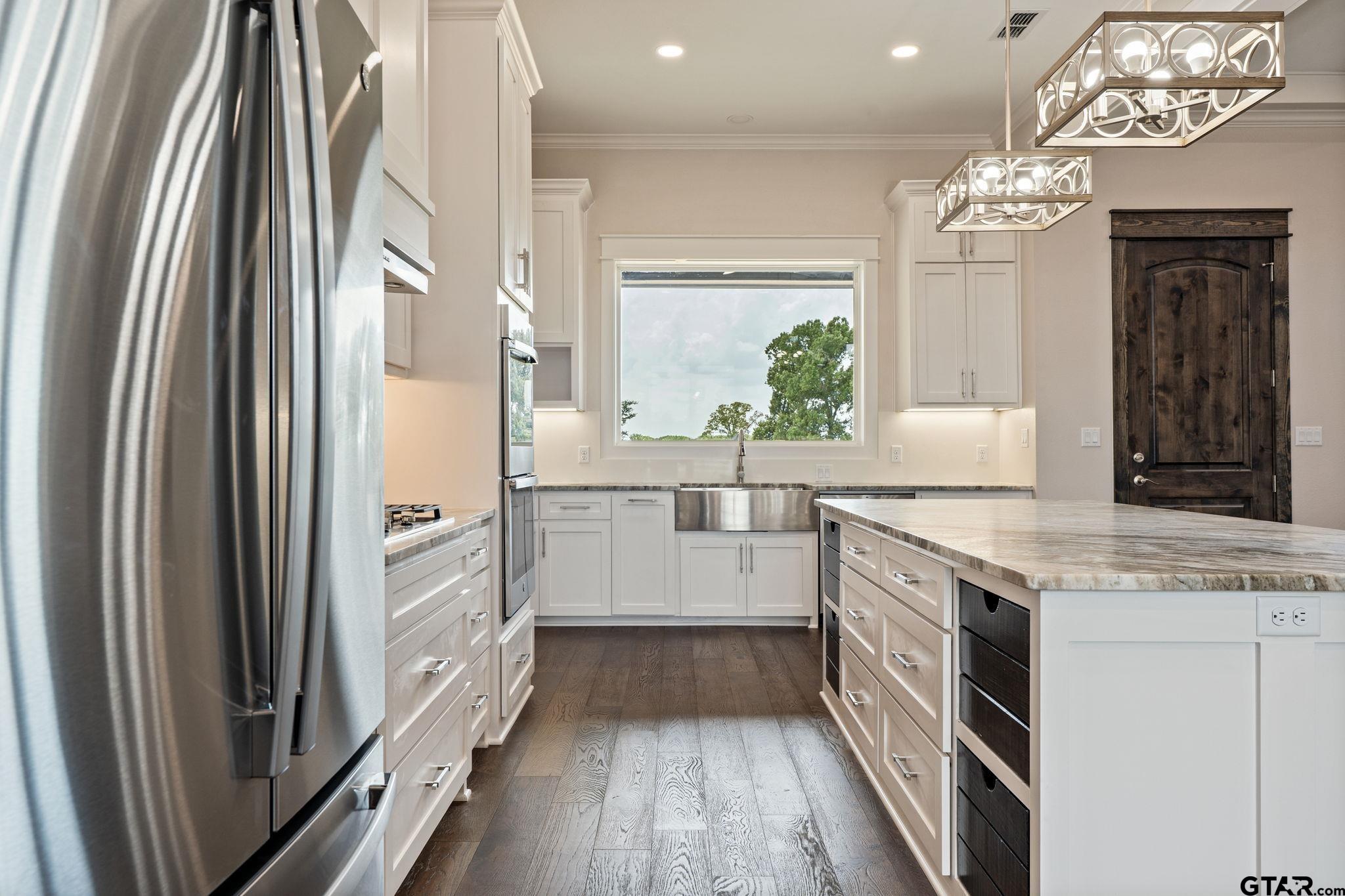 21064 Woodring Road Bullard, TX 75757 - Photo 24 of 48 a kitchen with stainless steel appliances a chandelier counter space and wooden floor