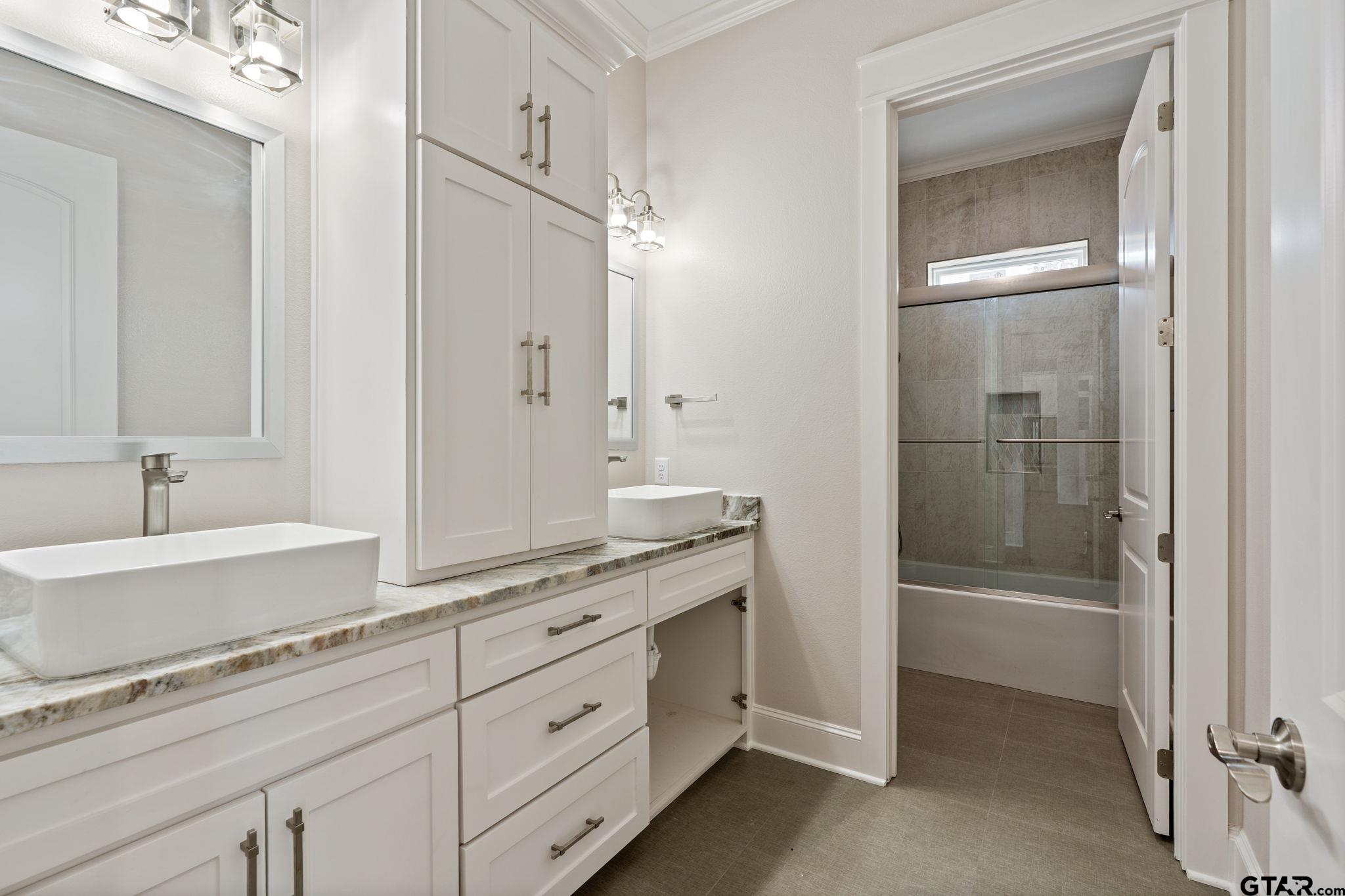 21064 Woodring Road Bullard, TX 75757 - Photo 31 of 48 a spacious bathroom with a granite countertop sink and a mirror