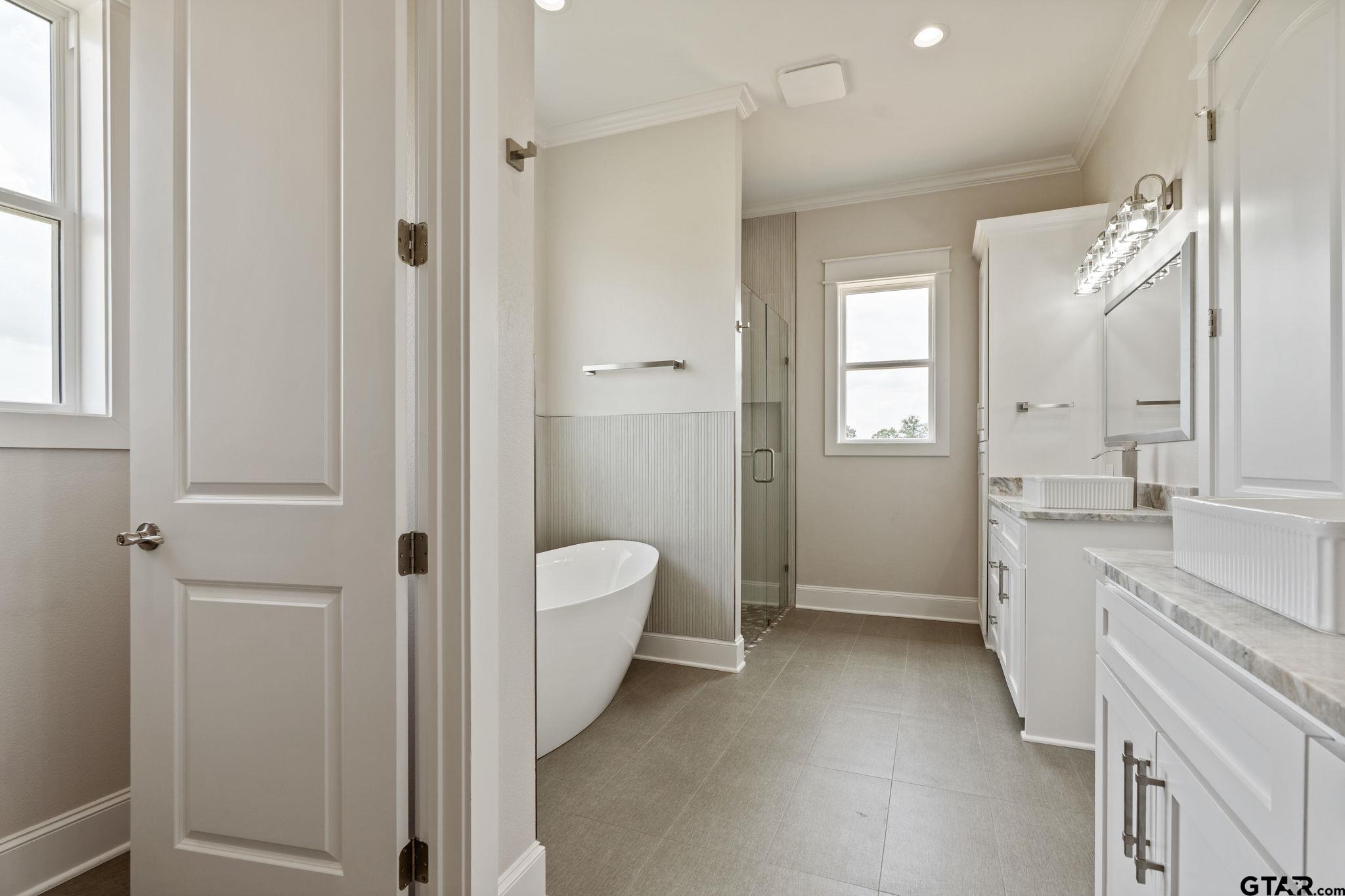 21064 Woodring Road Bullard, TX 75757 - Photo 39 of 48 a spacious bathroom with a double vanity sink a mirror and a shower
