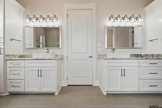 a kitchen with granite countertop white cabinets and wooden floor