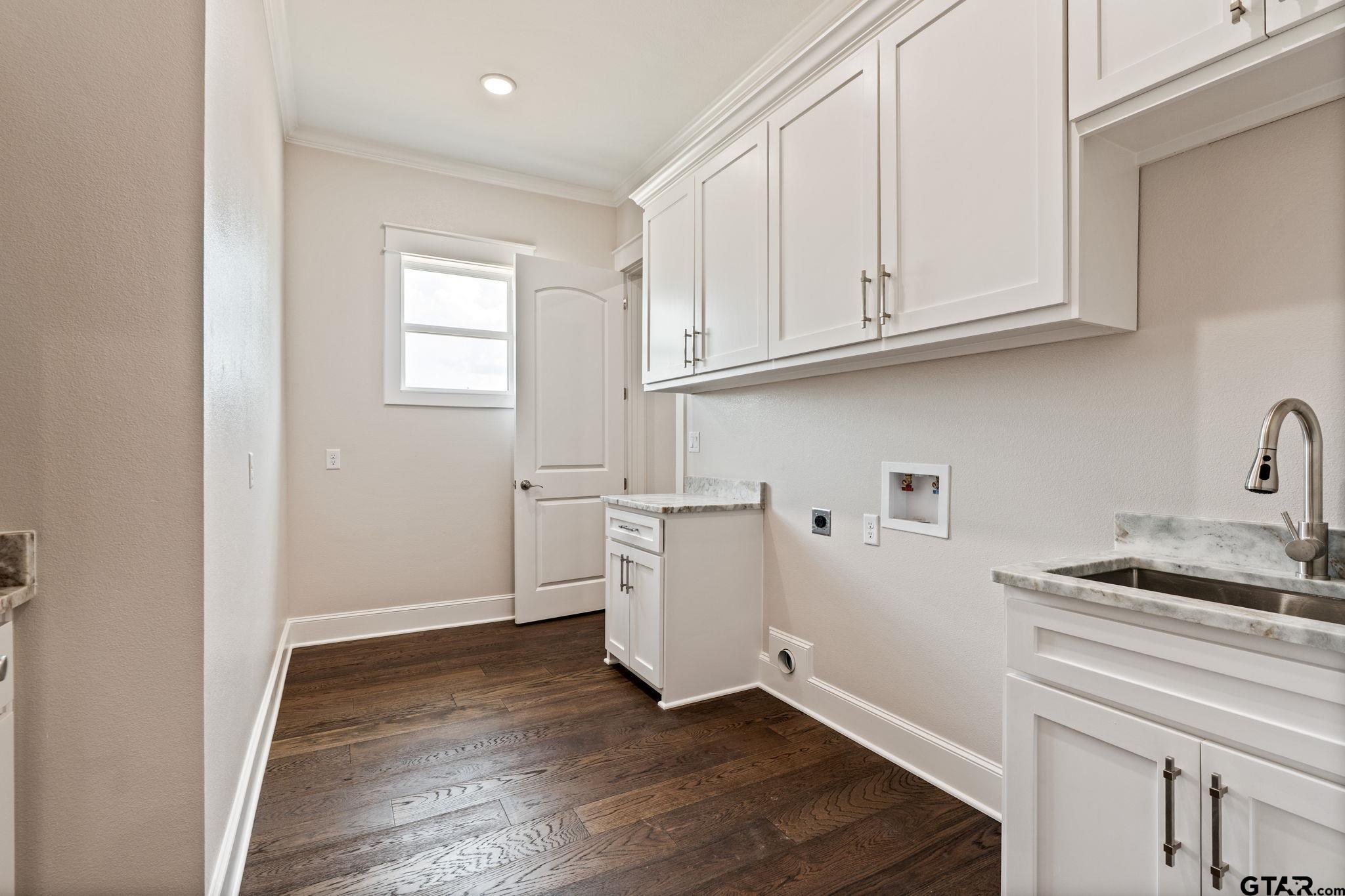 21064 Woodring Road Bullard, TX 75757 - Photo 43 of 48 a kitchen with granite countertop white cabinets and wooden floor