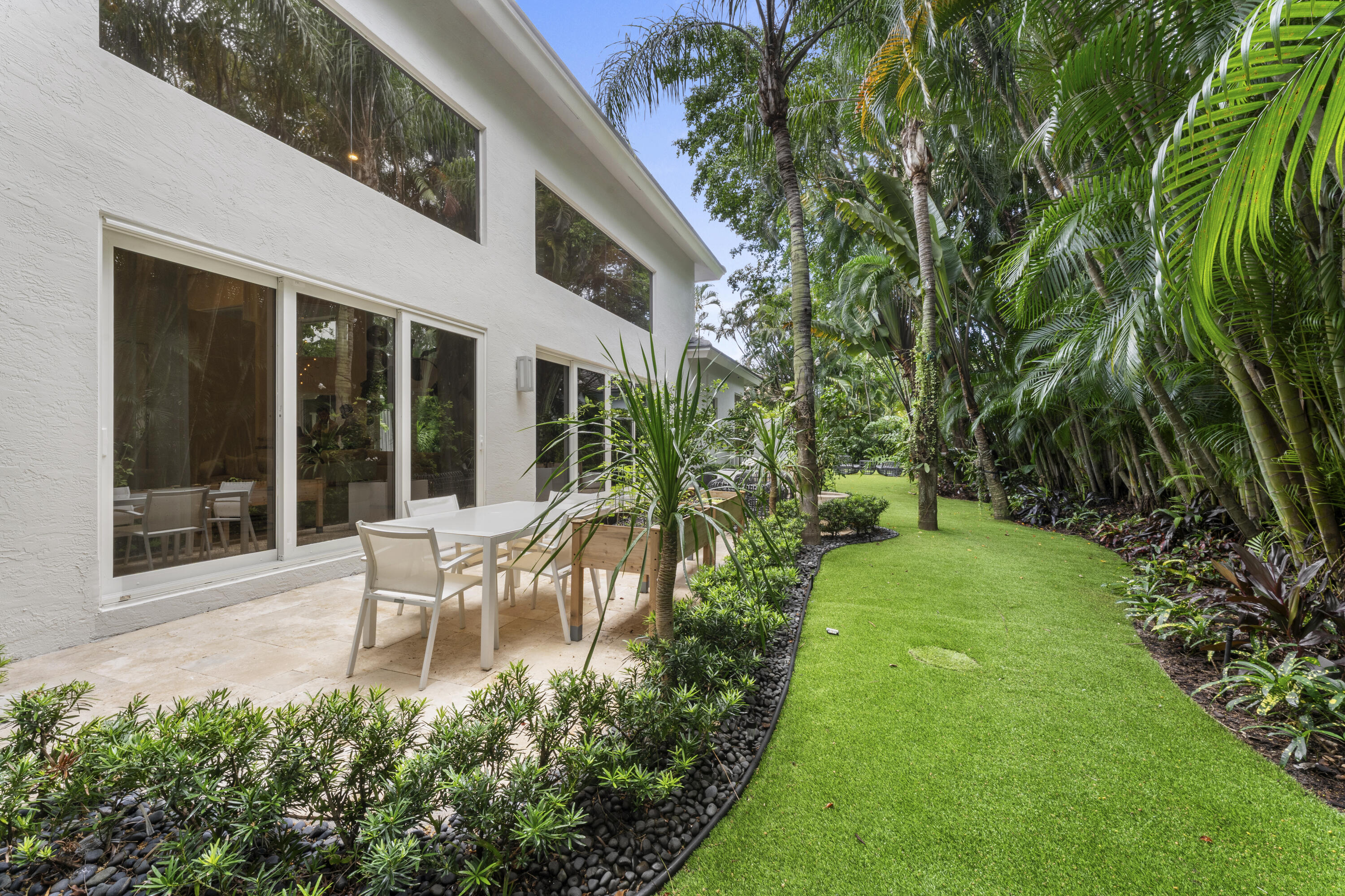 3156 Northwest 61st Street Boca Raton, FL 33496 - Photo 41 of 46 a view of a chair and table in backyard of the house