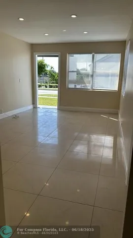 a view of a small space with wooden floor and a window