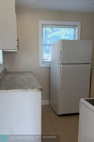 a sink with granite countertop white cabinets and a sink