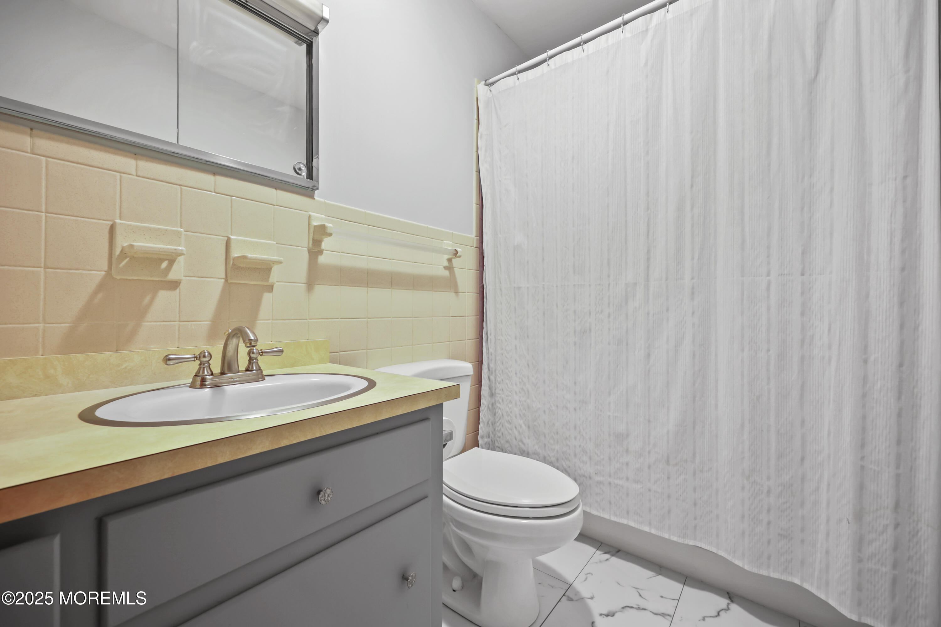 26 Edgewater Drive Matawan, NJ 07747 - Photo 16 of 23 a bathroom with a toilet a sink and curtain
