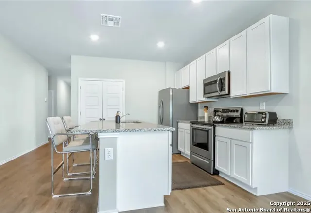 a kitchen with a stove a sink and a refrigerator