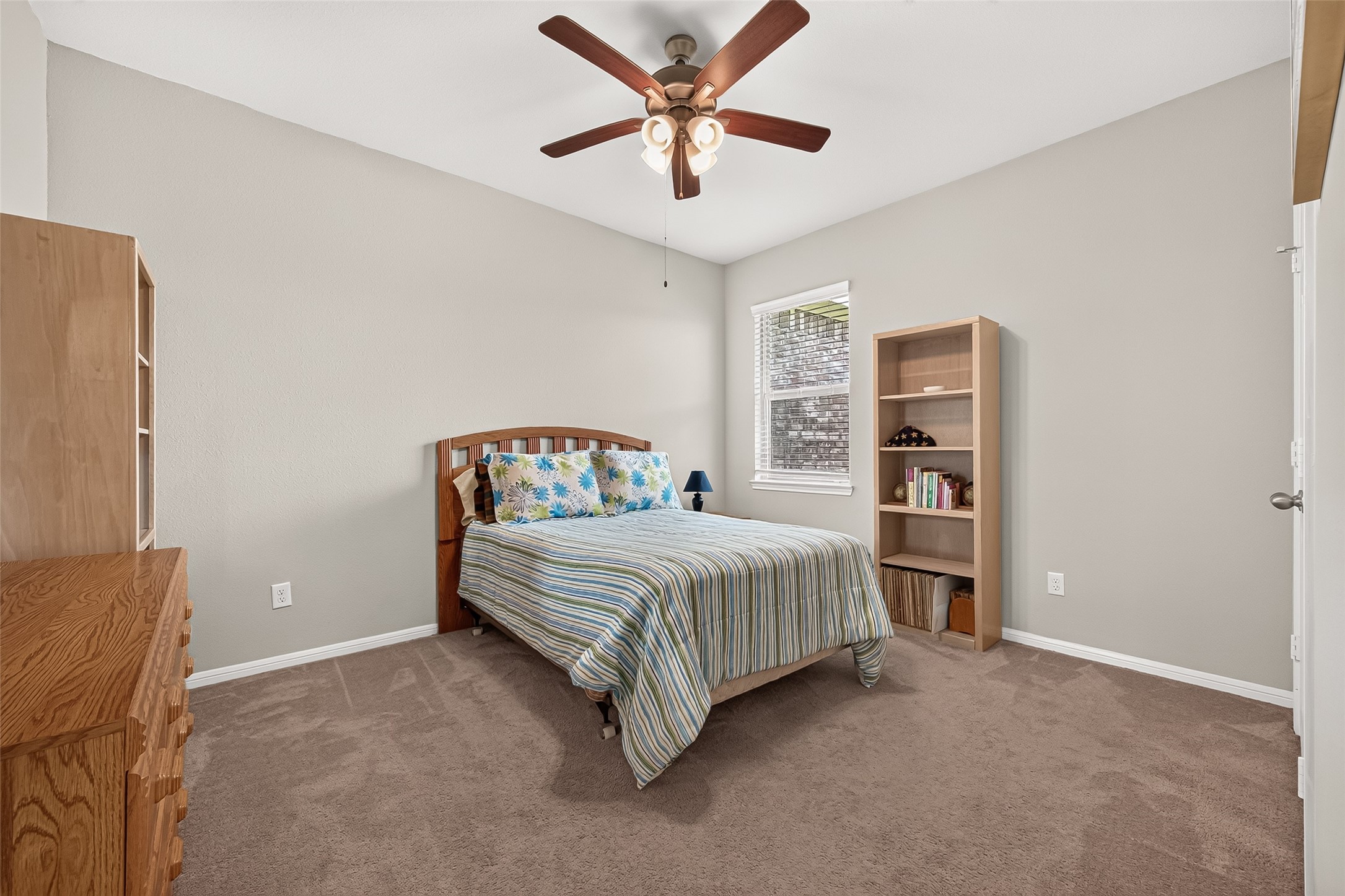 1329 Red Hills Drive Rosharon, TX 77583 - Photo 18 of 27 Secondary bedroom features a neutral color palette with carpeted flooring, a ceiling fan, and a window for natural light.