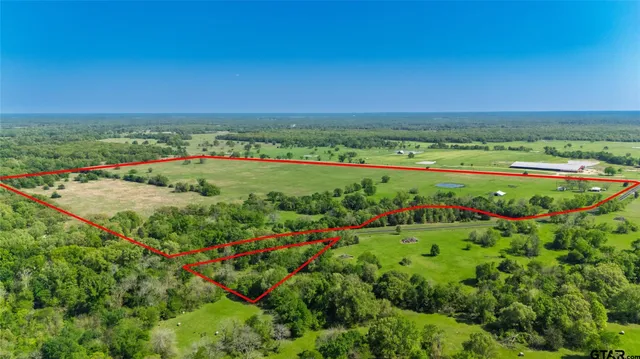 a view of a lush green outdoor space with a swimming pool and valleys in the background