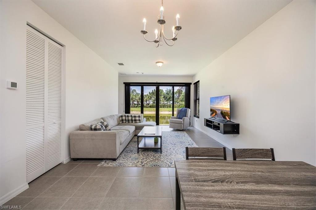 5547 Useppa Drive Ave Maria, FL 34142 - Photo 3 of 33 Living room featuring an inviting chandelier, baseboards, tile patterned floors, and visible vents