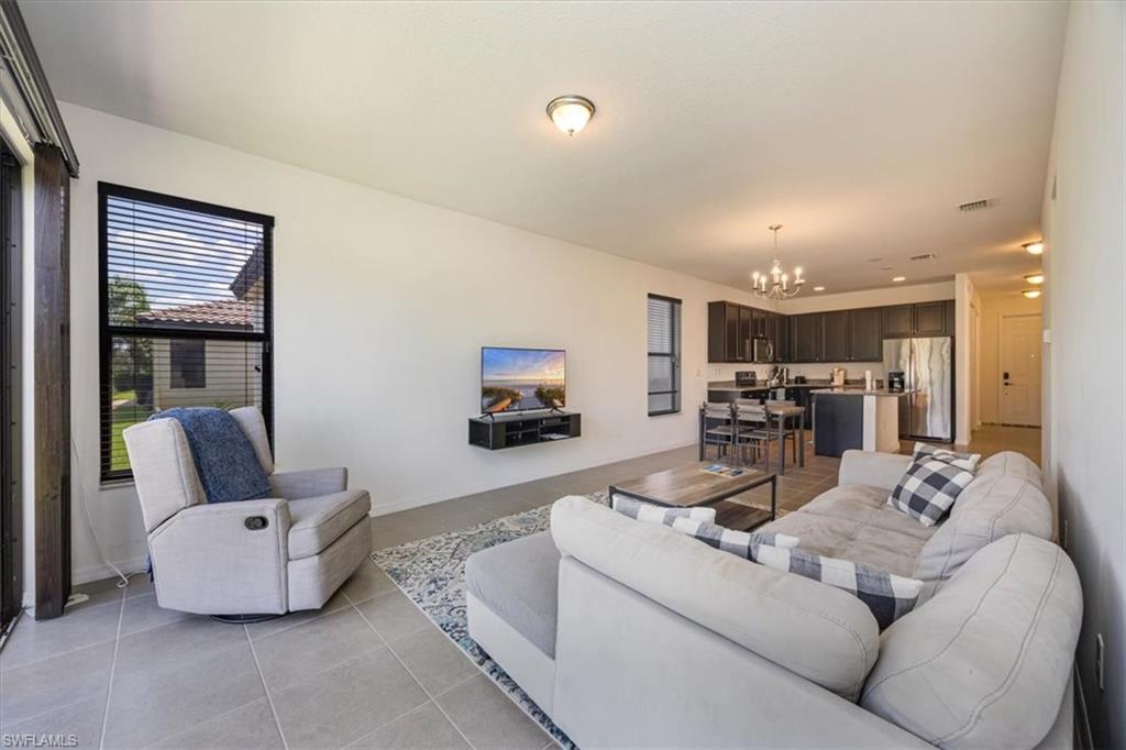 5547 Useppa Drive Ave Maria, FL 34142 - Photo 4 of 33 Living area with a notable chandelier, light tile patterned floors, and visible vents