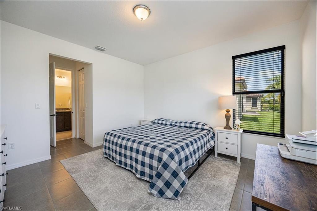 5547 Useppa Drive Ave Maria, FL 34142 - Photo 10 of 33 Bedroom featuring dark tile patterned flooring and baseboards