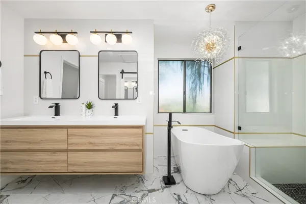 a bathroom with a double vanity sink mirror and bathtub