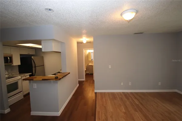 a kitchen with stainless steel appliances granite countertop a sink stove and white cabinets with wooden floor