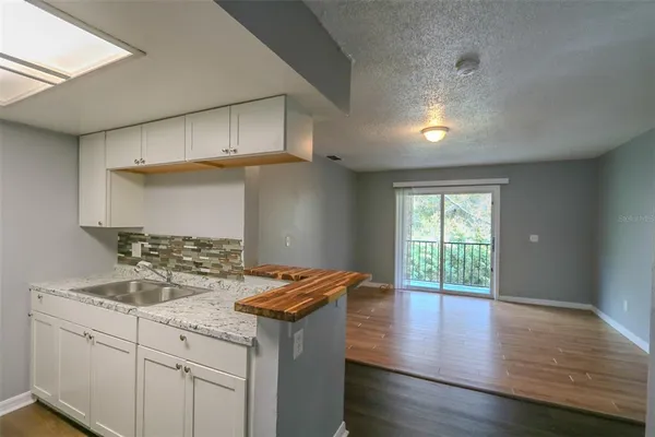 a kitchen with a sink cabinets and wooden floor