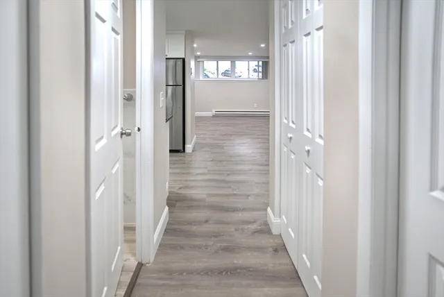 a view of an empty room with wooden floor and closet