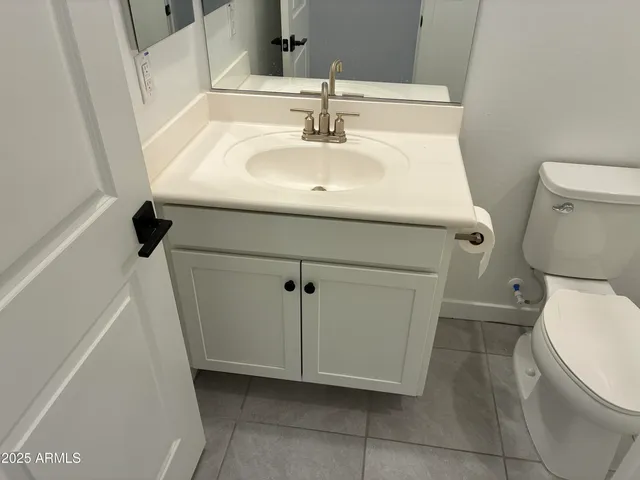 a bathroom with a sink a toilet and a mirror