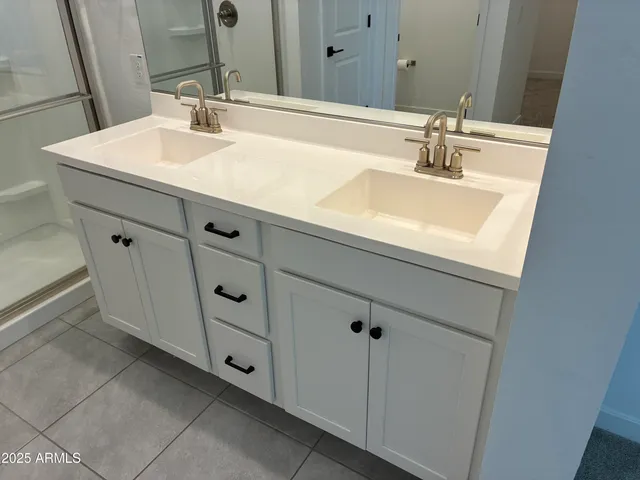 a bathroom with double sink and a mirror