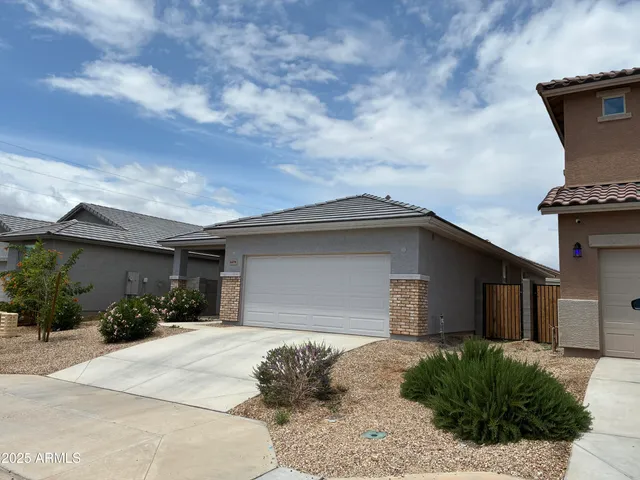 a backyard of a house with potted plants and brick wall