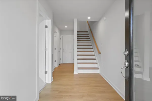a view of a hallway with wooden floor and entryway