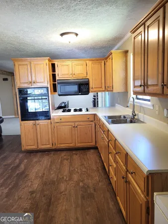 a large kitchen with stainless steel appliances kitchen island granite countertop a sink and cabinets